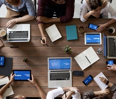 people sitting behind the desk with computers